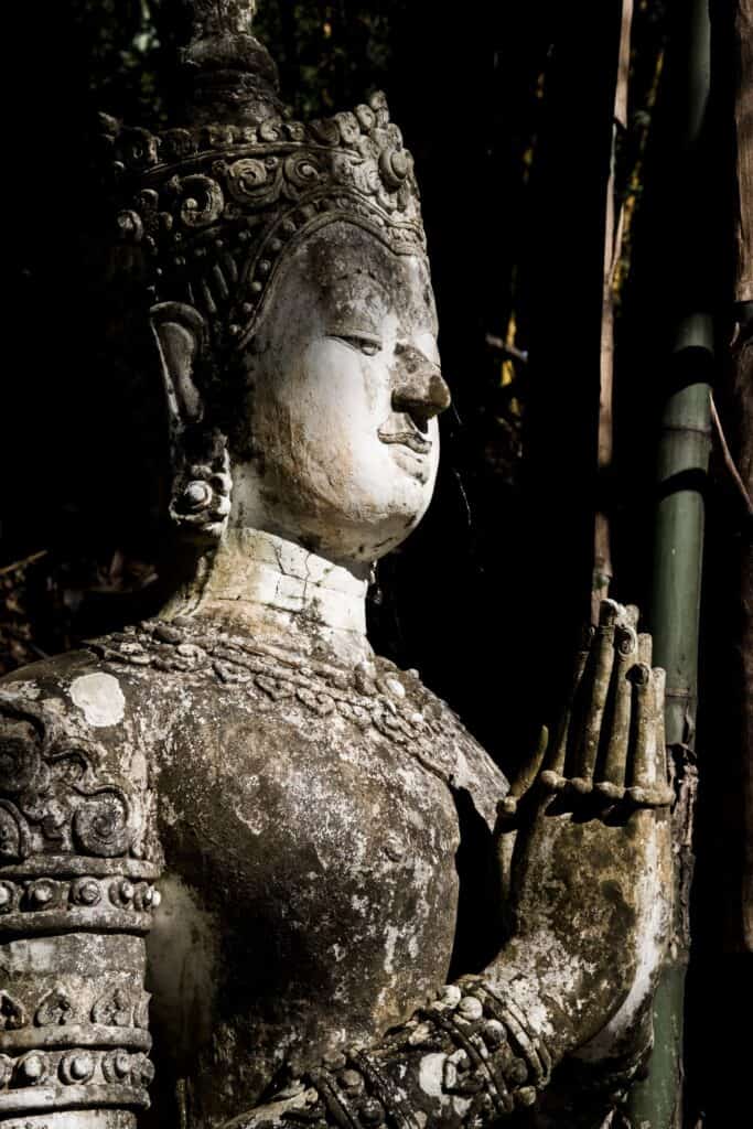 Stone statue of Buddha praying
